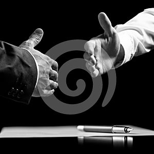 Businessmen about to shake hands over a signed contract photo