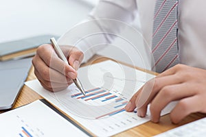 Businessmen use graphs to summarize results and calculate income-expenses to find financial balance points and use them to improve