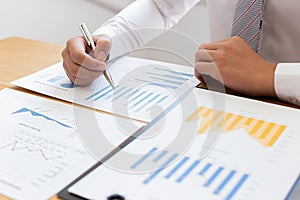 Businessmen use graphs to summarize results and calculate income-expenses to find financial balance points and use them to improve