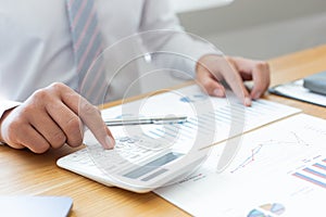 Businessmen use graphs to summarize results and calculate income-expenses to find financial balance points and use them to improve