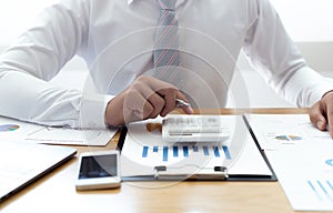 Businessmen use graphs to summarize results and calculate income-expenses to find financial balance points and use them to improve