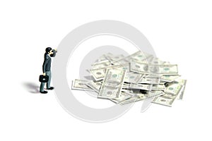 Businessmen using binoculars looking money cash paper pile from far