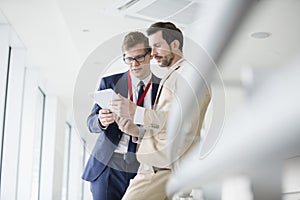 Businessmen using digital tablet in convention center