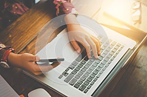 Businessmen are using their mobile to work with a laptop.