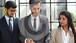 Businessmen and women standing side by side in an office corridor