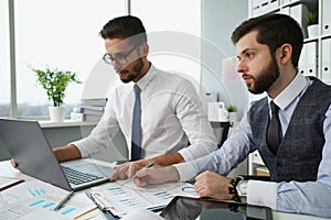 Businessmen work with financial papers, solve and discuss problems in office