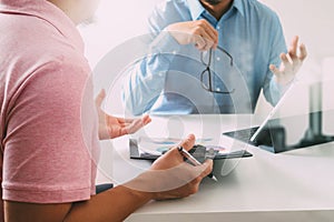 Businessmen working together on a document and using smart phone