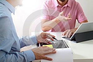 Businessmen working together on a document and using smart phone