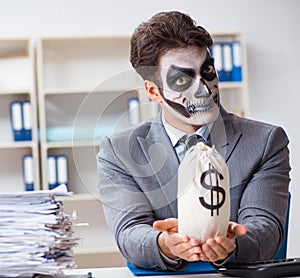 Businessmsn with scary face mask working in office