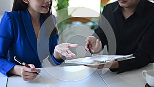 Businesspeople analyzing and discussing the situation on the financial report in meeting room.