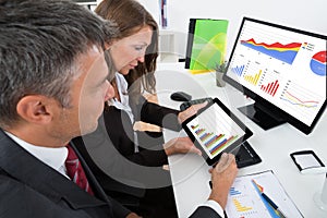 Businesspeople Analyzing Graph On Digital Tablet