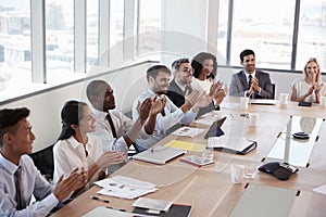 Businesspeople Around Boardroom Table Applaud Presentation