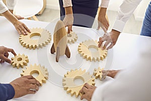 Businesspeople around office table with rocket and cogwheels deciding on company strategy