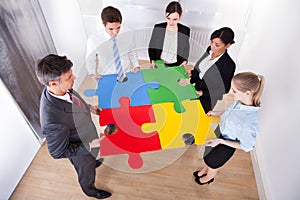 Businesspeople assembling jigsaw puzzle