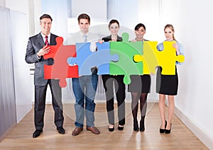 Businesspeople assembling jigsaw puzzle