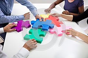 Businesspeople Building Colorful Jig Saw Puzzles Together photo