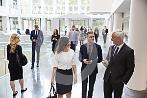 Businesspeople In Busy Lobby Area Of Modern Office