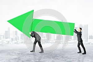 Businesspeople carrying green chart arrow
