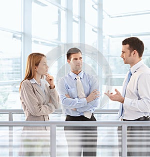 Businesspeople chatting in modern office lobby photo