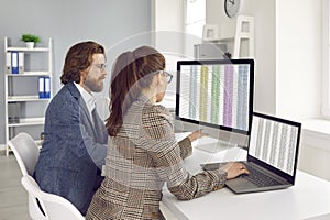Businesspeople collegues are working together in office with spreadsheets on computers screens.