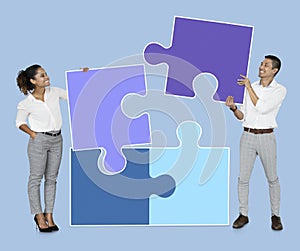 Businesspeople connecting jigsaw puzzle pieces