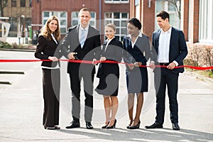 Businesspeople Cutting Ribbon