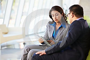 Businesspeople With Digital Tablet Sitting In Modern Office