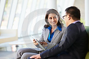 Businesspeople With Digital Tablet Sitting In Modern Office