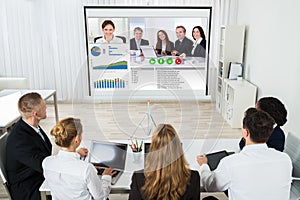 Businesspeople Discussing Graphs Through Videochat photo