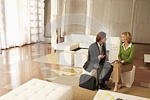 Businesspeople Discussing In Office Lobby