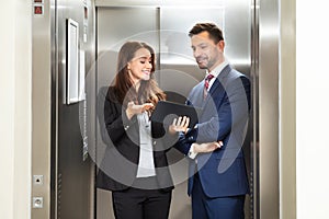 Businesspeople discussing standing near elevator