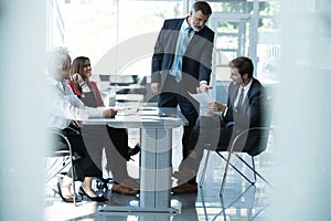 Businesspeople discussing together in conference room during meeting at office.