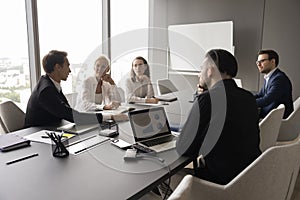 Businesspeople engaged in negotiations gathered together in modern conference room