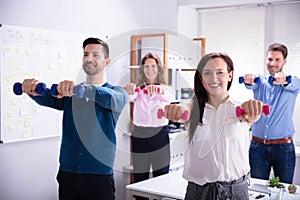 Businesspeople Exercising With Dumbbells