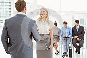 Businesspeople in front of people waiting for interview