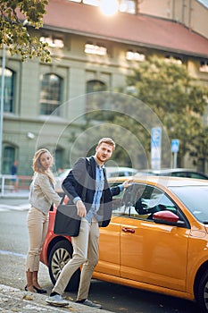 Businesspeople  getting out of a cab in the street