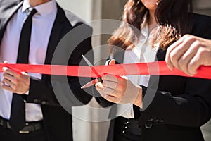 Businesspeople Hand Cutting Red Ribbon photo