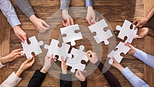 Businesspeople Hand Solving Jigsaw Puzzle