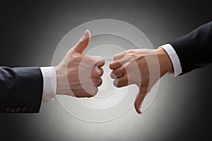 Businesspeople hands showing thumb up and thumb down