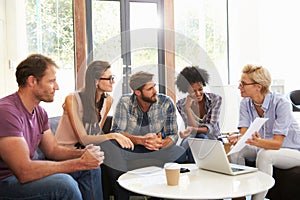 Businesspeople Having Informal Meeting In Modern Office