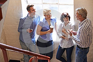 Businesspeople Having Informal Meeting On Office Stairs