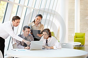 Businesspeople Having Meeting Around Table In Modern Office