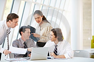 Businesspeople Having Meeting Around Table In Modern Office