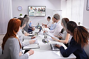 Businesspeople Having Video Conference In Boardroom