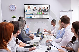 Businesspeople Having Video Conference In Boardroom