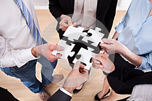 Businesspeople holding jigsaw puzzle