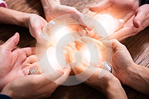 Businesspeople Holding Light Bulbs In Hand