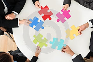 Businesspeople holding multi-colored jigsaw puzzle