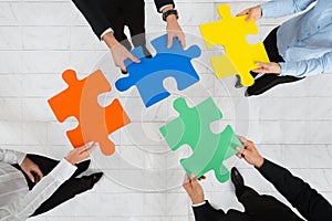 Businesspeople Holding Puzzle Pieces