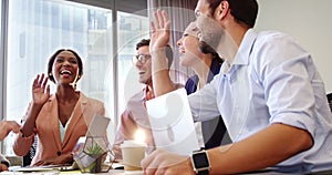 Businesspeople interacting and giving high five to each other